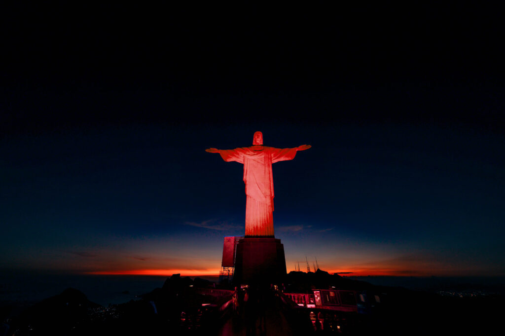 Cristo é iluminado em vermelho para festejar o Dia do Bombeiro e o aniversário da corporação