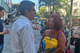 O candidato do PP à Prefeitura do Rio, Marcelo Queiroz, conversa com uma eleitora na calçada, que o segurança diz se tratar de uma "expansão do shopping"