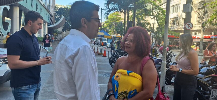 O candidato do PP à Prefeitura do Rio, Marcelo Queiroz, conversa com uma eleitora na calçada, que o segurança diz se tratar de uma "expansão do shopping"