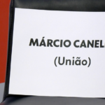 na imagem, cadeira vazia com um papel com o nome de Marcio Canella