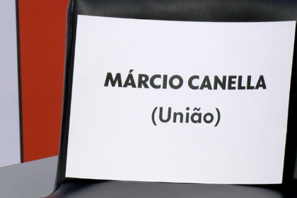 na imagem, cadeira vazia com um papel com o nome de Marcio Canella