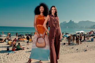 duas modelos, uma de vestido e outra de conjunto, posam em frente a praia do arpoador, no rio de janeiro