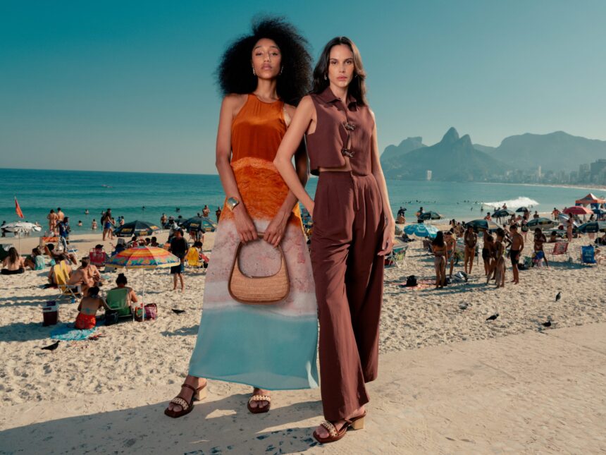 duas modelos, uma de vestido e outra de conjunto, posam em frente a praia do arpoador, no rio de janeiro