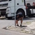 Homem é flagrado tentando arrancar poste para passar com caminhão em calçada