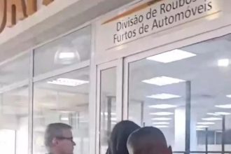 Políciais civis chegam à Delegacia de Roubos e Furtos de Automóveis com um dos mais de 200 presos na Operação Espoliador