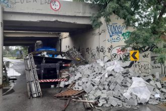 Caminhão com material de construção tomba e fecha acesso na Avenida das Américas
