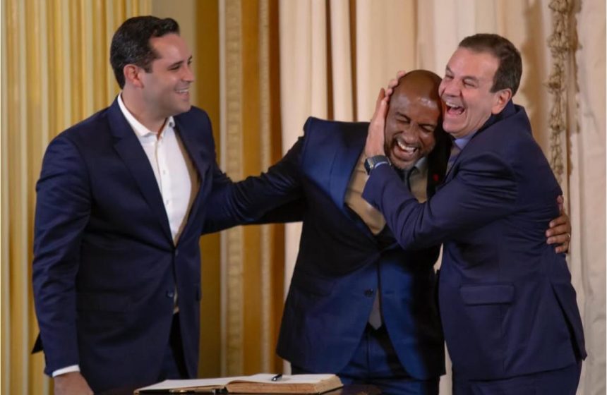 O vice-prefeito Eduardo Cavaliere observa Edson Menezes, o Edinho, ser efusivamente cumprimentado por Eduardo Paes: a dupla Cavaliere e Edinho formam o "caminho das pedras" na Prefeitura do Rio