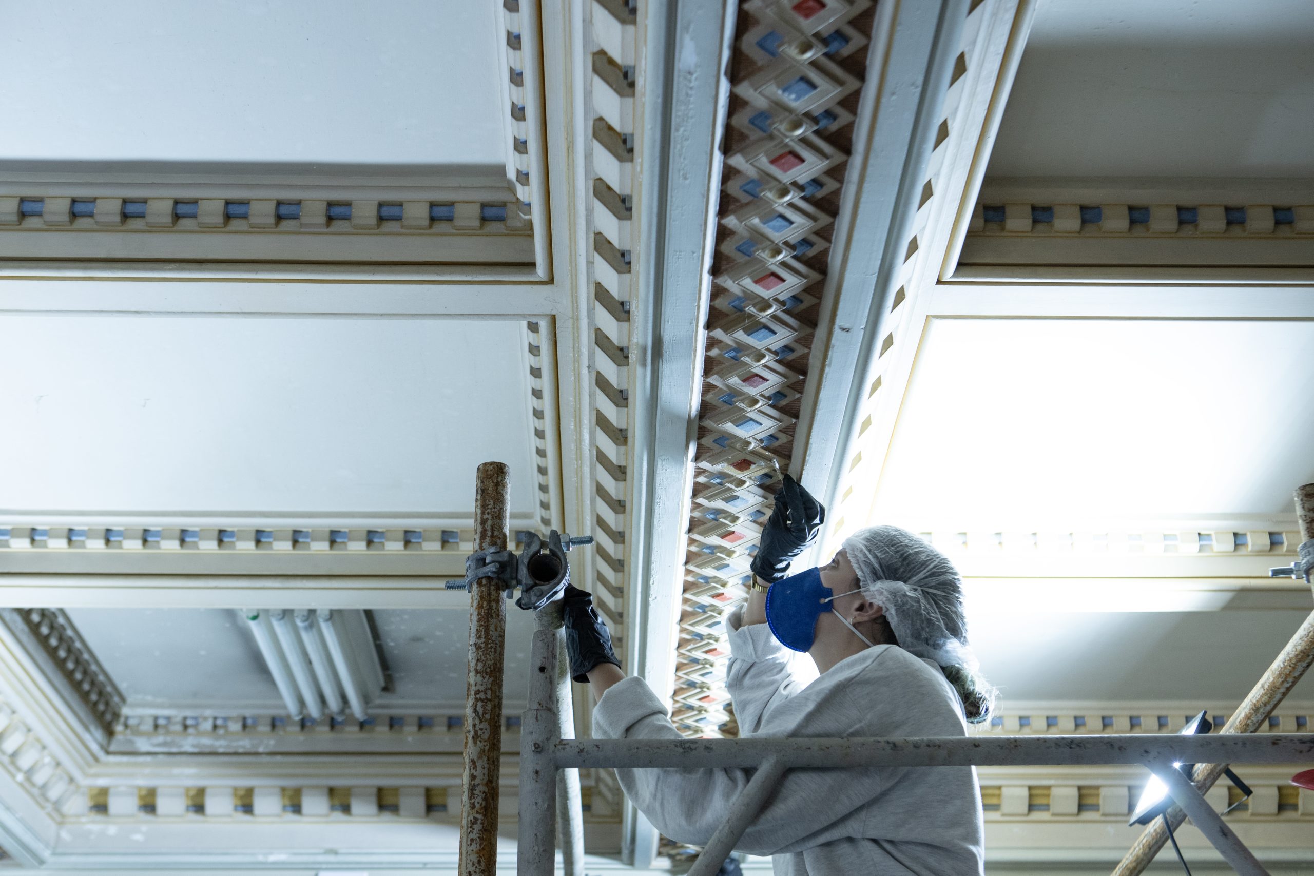 O processo de restauração do palacete do Parque Lage envolve o trabalho minucioso de profissionais especializados, com a remoção cuidadosa de camadas de tinta para preservar a pintura original das paredes e teto do patrimônio histórico