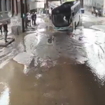 Ônibus fica preso em buraco na Rua Figueira de Melo, em São Cristóvão, após vazamento de esgoto
