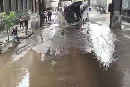 Ônibus fica preso em buraco na Rua Figueira de Melo, em São Cristóvão, após vazamento de água