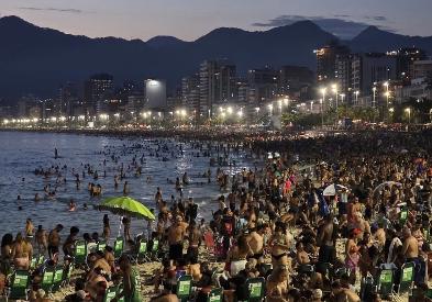 Praia do Arpoador lotada no começo de uma noite de verão no Rio 40°C: onda de calor extremo impulsiona e desafia o espírito rueiro do carioca