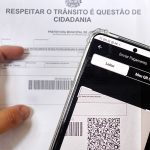 Pessoa efetuando pagamento de multa por PIX. Detran.