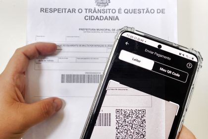 Pessoa efetuando pagamento de multa por PIX. Detran.