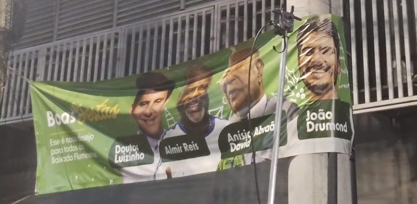 A faixa com Anísio Abraão David e o presidente da Beija-Flor, Almir Reis, ladeados por Doutor Luizinho e João Drumond, pendurada na Avenida Mirandela, onde a escola ensaia, em Nilópolis