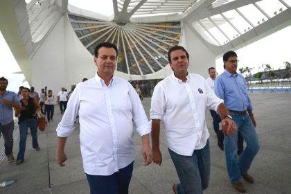 Gilberto Kassab, presidente do PSD, caminha ao lado do prefeito Eduardo Paes, tendo o Museu do Amanhã ao fundo