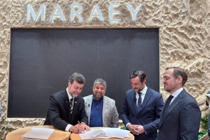 Marcelo Freixo, presidente da Embratur, assina documento durante a FITUR, em Madri, ao lado do prefeito de Maricá, Washington Quaquá, e representantes do setor turístico.