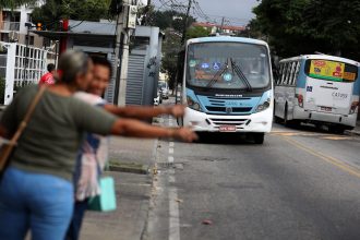 Passageiros fazem "sinal" para ônibus no Rio
