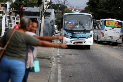 Passageiros fazem "sinal" para ônibus no Rio