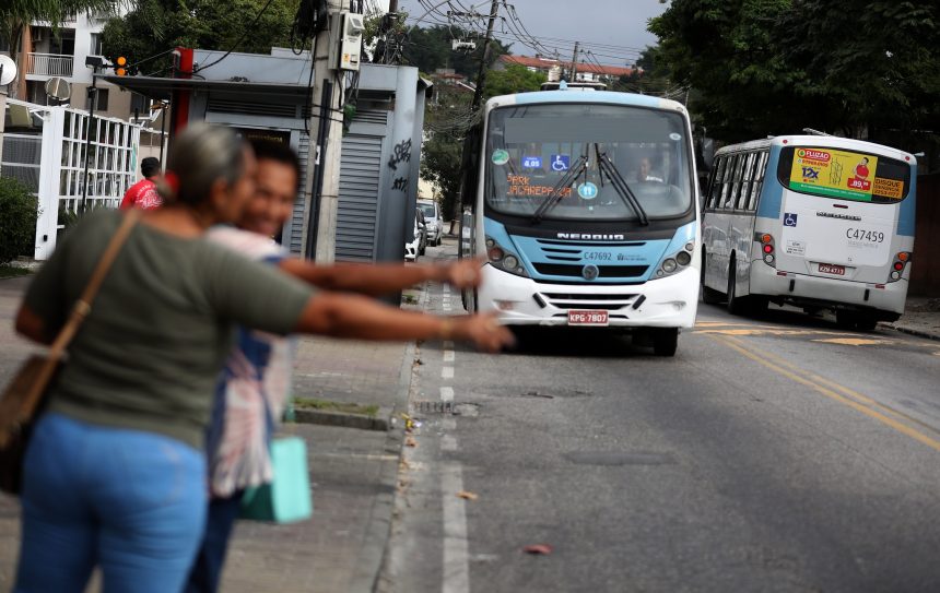 Passageiros fazem "sinal" para ônibus no Rio