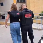 Ana Paula Alexandre Novello, acusada de gerenciar bingo clandestino, sendo conduzida por agente do MPRJ à delegacia
