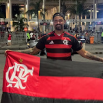 Ex-goleiro Bruno segurando bandeira do Flamengo em frente ao Maracanã