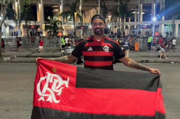 Ex-goleiro Bruno segurando bandeira do Flamengo em frente ao Maracanã