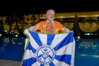 Presidente Lula segura bandeira da Acadêmicos de Niterói, escola que o homenageia em desfile neste domingo (15)