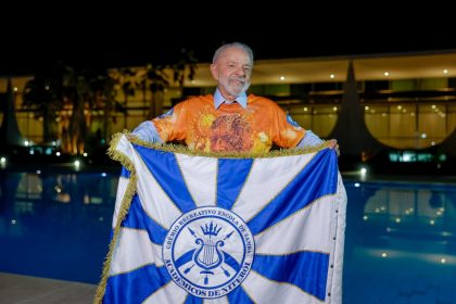 Presidente Lula segura bandeira da Acadêmicos de Niterói, escola que o homenageia em desfile neste domingo (15)