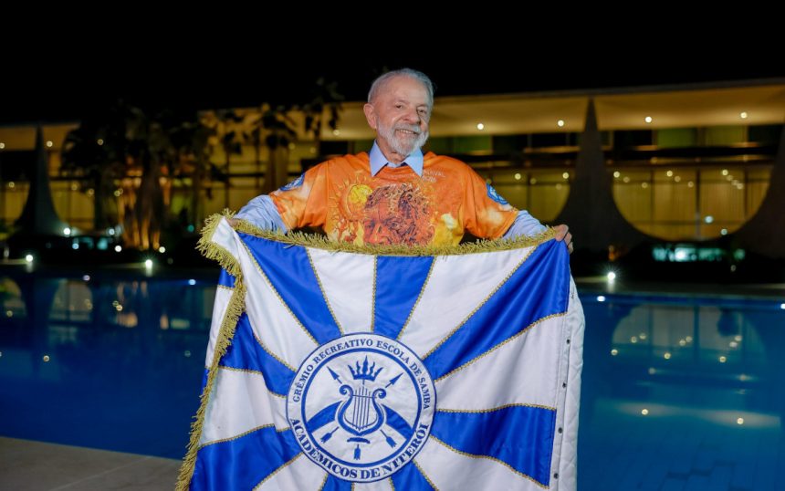Presidente Lula segura bandeira da Acadêmicos de Niterói, escola que o homenageia em desfile neste domingo (15)