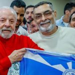 O presidente Luiz Inácio Lula da Silva e Pipico, presidente de honra da escola, exibem a bandeira da agremiação citada no relatório do TCU que questiona o uso de verbas federais.