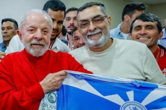O presidente Luiz Inácio Lula da Silva e Pipico, presidente de honra da escola, exibem a bandeira da agremiação citada no relatório do TCU que questiona o uso de verbas federais.