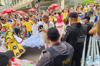 Policiais militares patrulham rua durante desfile de bloco de carnaval no Rio