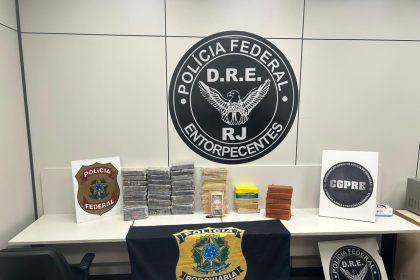 Uma ação integrada da Polícia Federal e da Polícia Rodoviária Federal resultou na apreensão de cerca de 54 quilos de pasta base de cocaína na tarde desta sexta-feira (20), na Rodovia Presidente Dutra, na altura do km 227, em Piraí, no Sul Fluminense. A operação ocorreu no âmbito da Missão Redentor II. As equipes interceptaram um caminhão-trator acoplado a um semirreboque e, durante a fiscalização, localizaram aproximadamente 54 kg da droga acondicionados em caixas. Segundo as investigações, o motorista teria retirado o carregamento em Mogi das Cruzes e seguia em direção ao Rio. Ele foi preso em flagrante e encaminhado, junto com o veículo e o material apreendido, para a Superintendência Regional da PF no Rio. A ocorrência contou com a participação de policiais das Delegacias de Repressão a Drogas do Rio (DRE/RJ) e de São Paulo (DRE/SP), além do Grupo de Investigações Sensíveis (GISE/PF/RJ). De acordo com a PF, a apreensão representa um impacto relevante na logística do crime organizado. A pasta base, após refinada, poderia gerar um volume muito maior de droga para abastecer o varejo nas comunidades fluminenses. O motorista vai responder por tráfico interestadual de drogas. A ação integra a Missão Redentor II, realizada no contexto da ADPF 635, com foco na descapitalização de organizações criminosas e no bloqueio de rotas de transporte de armas e entorpecentes para áreas urbanas do estado.