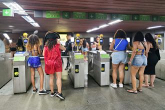 Foliões passam por catraca em estação do MetrôRio