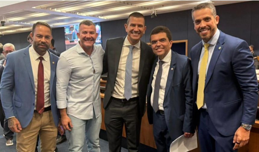 Douglas Ruas (PL) e Chico Machado (SDD) abraçados em plenário, ladeados da tropa de choque da Alerj, Rodrigo Amorim (União), Alan Lopes (PL) e Filippe Poubel (PL)