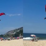 Homem sobrevoa banhistas de parapente em Ipanema