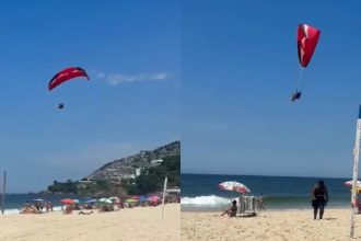 Homem sobrevoa banhistas de parapente em Ipanema