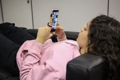 Adolescente usando celular; vítima de violência psicológica digital
