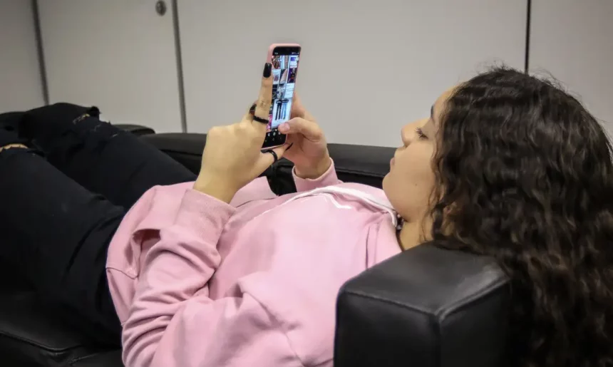 Adolescente usando celular; vítima de violência psicológica digital