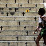Mulher caminha em frete à homenagem feita a vítimas de feminícidios no Rio