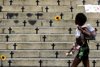 Mulher caminha em frete à homenagem feita a vítimas de feminícidios no Rio