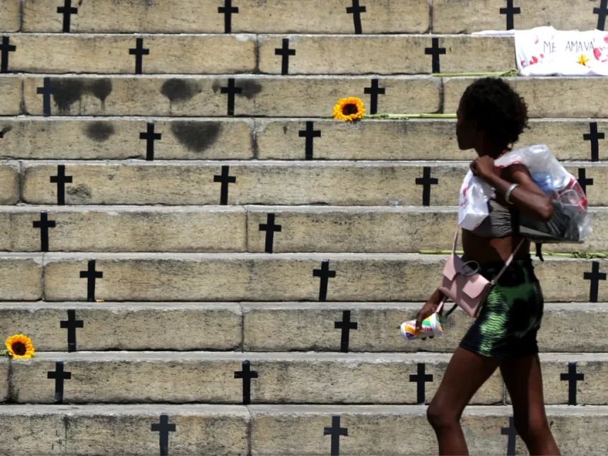 Mulher caminha em frete à homenagem feita a vítimas de feminícidios no Rio