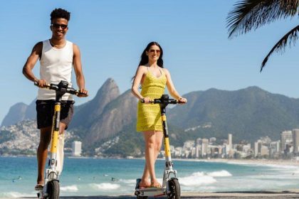 Homem e mulher passeiam no Rio em patinetes elétricos