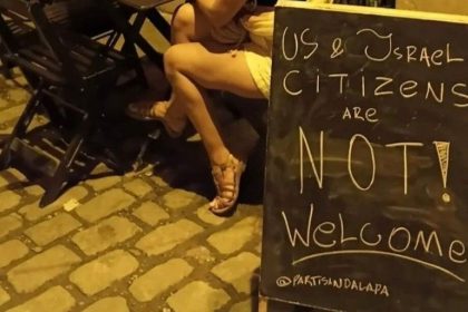 Placa colocada na entrada do Partisan, bar na Lapa