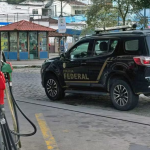 Viatura da Polícia Federal em posto de combustível durante investigações sobre esquema de lavagem de dinheiro do jogo do bicho