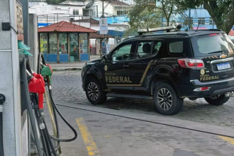 Viatura da Polícia Federal em posto de combustível durante investigações sobre esquema de lavagem de dinheiro do jogo do bicho