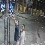 O casal derruba o poste para arrancar a placa na Rua Arnaldo Quintela