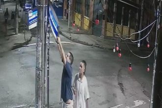 O casal derruba o poste para arrancar a placa na Rua Arnaldo Quintela
