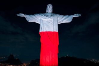 Cristo Redentor com as cores branca e vermelha, em homenagem a Polônia