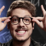 Fábio Porchat sorrindo com a mão nos óculos